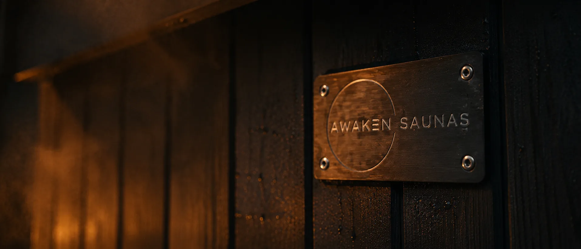 An engraved Awaken Saunas maker's badge on the timber side of a handcrafted sauna